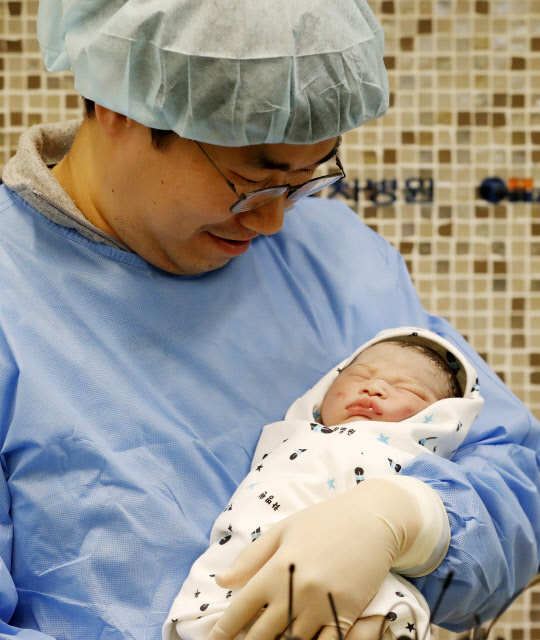1월 1일 0시 0분 서울 강남구 차병원에서 태어난 이혜림(33)씨와 우명제(37)씨의 딸 우성(태명)양이 아빠 품에 안겨있다.  연합뉴스